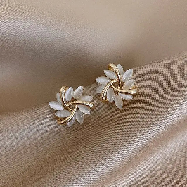 Boucles d’oreilles clous feuille en or avec opale blanche