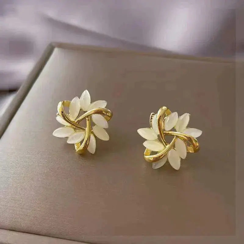 Boucles d’oreilles clous feuille en or avec opale blanche